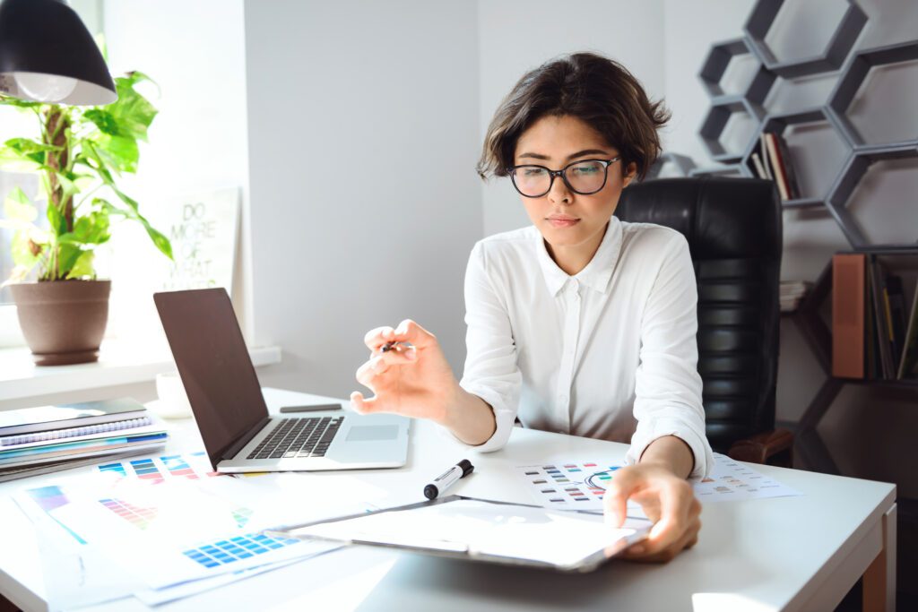 Woman working at desk with laptop.