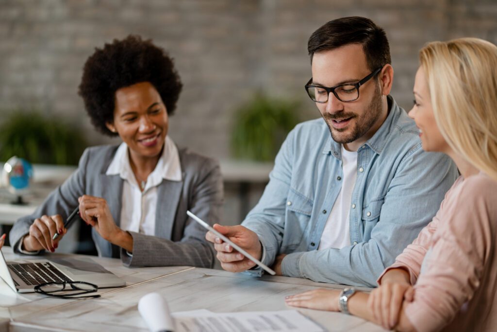 Three people discussing work at a table.