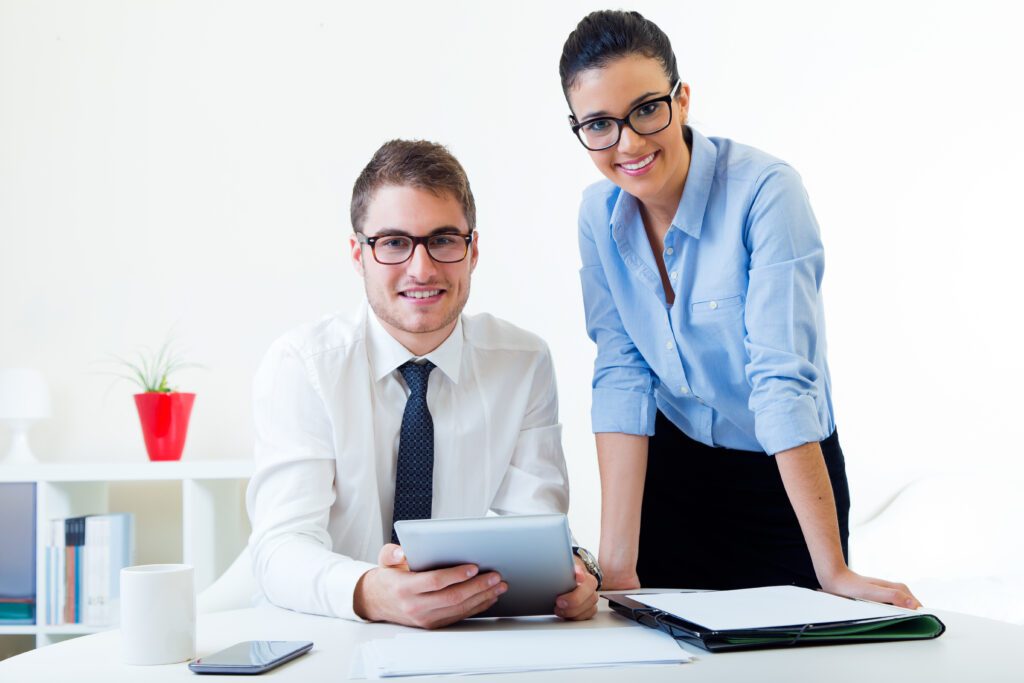 Two colleagues smiling in an office setting.